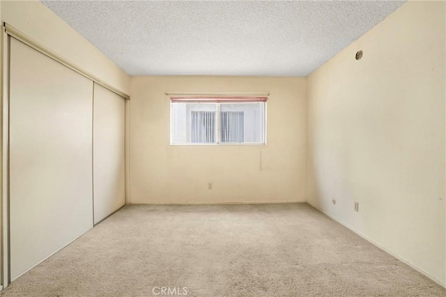 13903 Sherman Way Unit 8, Van Nuys, CA 91405 - unfurnished bedroom featuring light carpet, a closet, and a textured ceiling