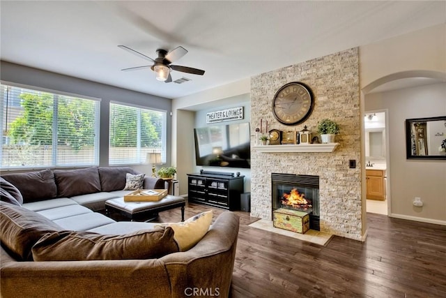 44837 Checkerbloom Dr, Temecula, CA 92592 - living area with a ceiling fan, a fireplace, dark wood-style flooring, and arched walkways