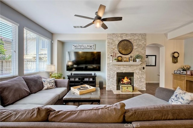 44837 Checkerbloom Dr, Temecula, CA 92592 - living area featuring a ceiling fan, arched walkways, dark wood finished floors, and a fireplace