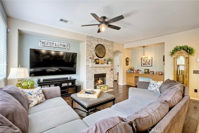 44837 Checkerbloom Dr, Temecula, CA 92592 - living room with dark wood-type flooring, ceiling fan, arched walkways, and a fireplace