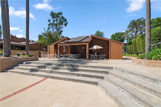 9411 Friendly Woods Ln, Whittier, CA 90605 - back of house featuring outdoor dining area, a patio area, and roof mounted solar panels