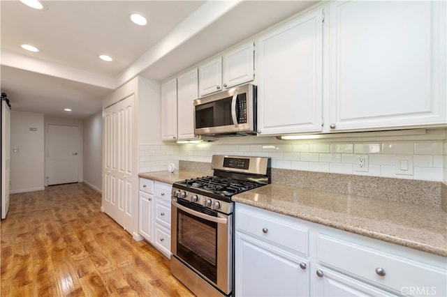 9411 Friendly Woods Ln, Whittier, CA 90605 - kitchen featuring stainless steel appliances, white cabinetry, decorative backsplash, light wood-type flooring, and recessed lighting