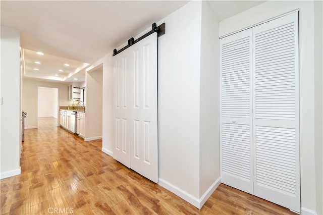 9411 Friendly Woods Ln, Whittier, CA 90605 - hall featuring a barn door, light wood-style flooring, recessed lighting, and a raised ceiling