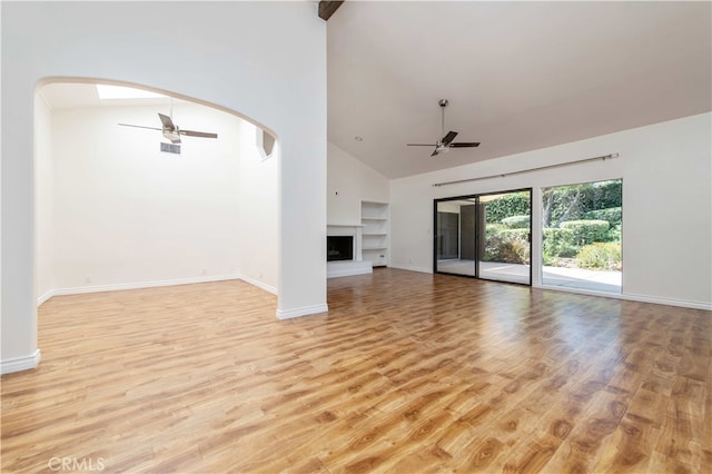 9411 Friendly Woods Ln, Whittier, CA 90605 - unfurnished living room with ceiling fan, light wood-style floors, high vaulted ceiling, arched walkways, and built in features
