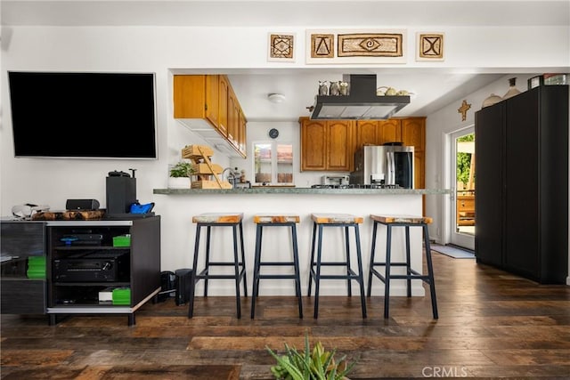 2023 Republic Ave, Costa Mesa, CA 92627 - kitchen featuring stainless steel fridge, brown cabinets, dark wood-style flooring, a breakfast bar, and a peninsula