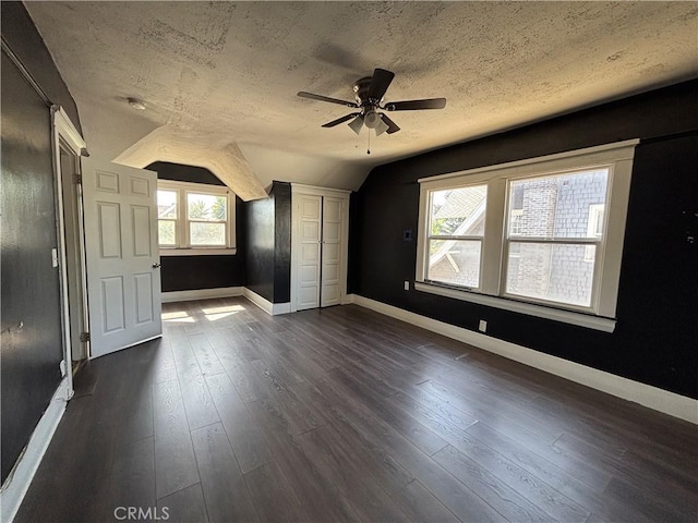 1646 Cimarron St, Los Angeles, CA 90019 - unfurnished bedroom featuring vaulted ceiling, a textured ceiling, dark wood finished floors, and ceiling fan