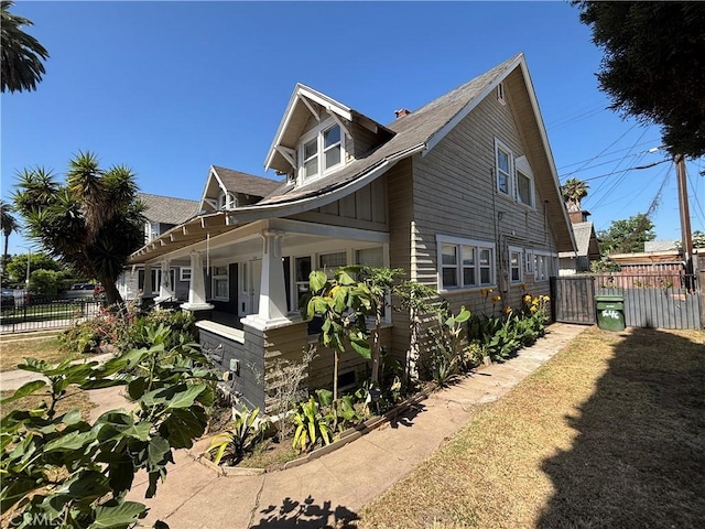 1646 Cimarron St, Los Angeles, CA 90019 - view of side of home with covered porch and a shingled roof
