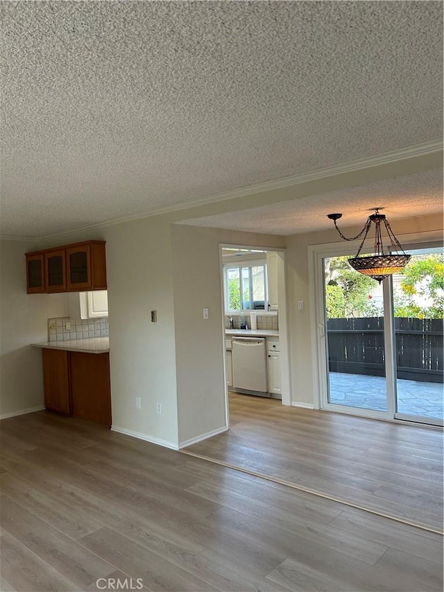 22943 Maple Ave Unit A, Torrance, CA 90505 - unfurnished dining area with a textured ceiling, ornamental molding, and light wood-type flooring