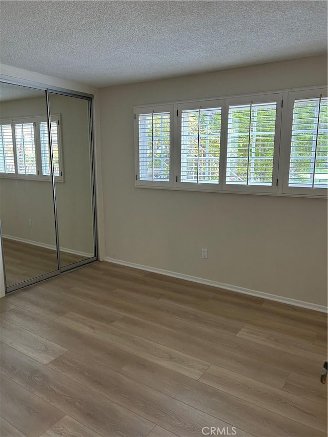 22943 Maple Ave Unit A, Torrance, CA 90505 - unfurnished bedroom featuring light wood-style floors, a textured ceiling, and a closet