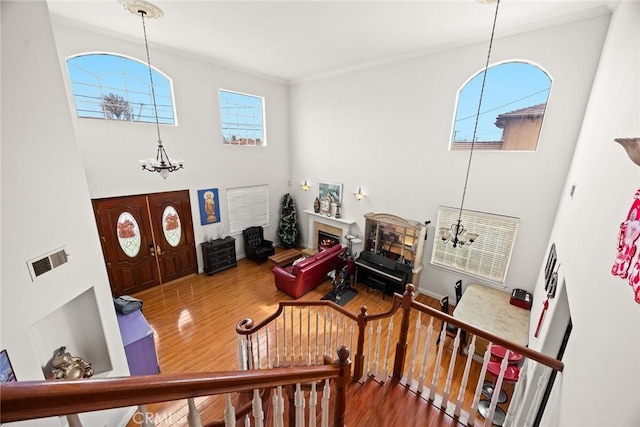 3453 Ivar Ave, Rosemead, CA 91770 - entrance foyer with a chandelier, crown molding, wood finished floors, a tiled fireplace, and a towering ceiling