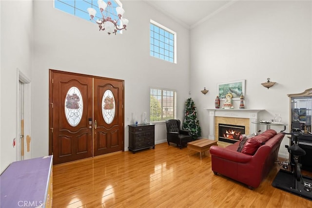 3453 Ivar Ave, Rosemead, CA 91770 - foyer entrance with light wood-style flooring, a towering ceiling, crown molding, a glass covered fireplace, and a chandelier
