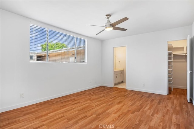 5429 Newcastle Ave Unit 309, Encino, CA 91316 - unfurnished bedroom with a spacious closet, light wood finished floors, a closet, ensuite bathroom, and a ceiling fan