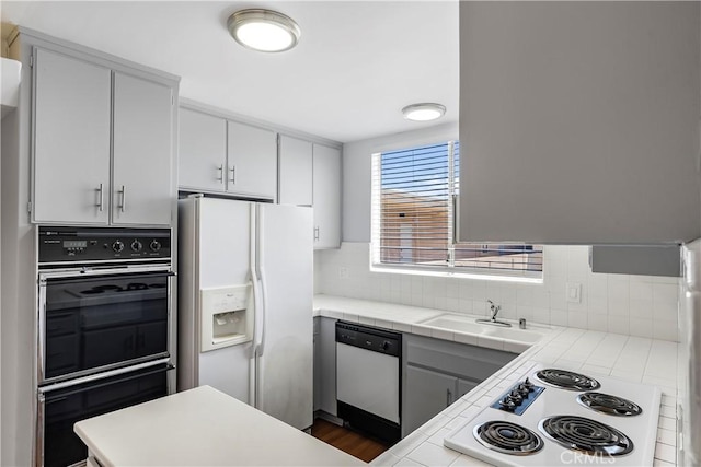 5429 Newcastle Ave Unit 309, Encino, CA 91316 - kitchen with white appliances, tile counters, decorative backsplash, and white cabinets