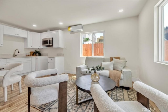 123 W 56th St, Los Angeles, CA 90037 - living area featuring a wall mounted air conditioner, healthy amount of natural light, light wood-style flooring, and recessed lighting