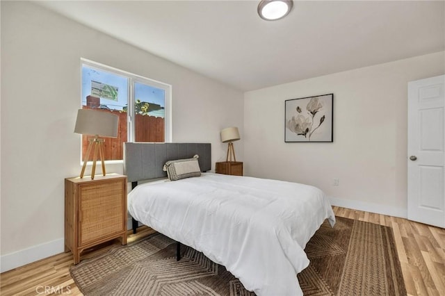 123 W 56th St, Los Angeles, CA 90037 - bedroom with light wood-type flooring and baseboards