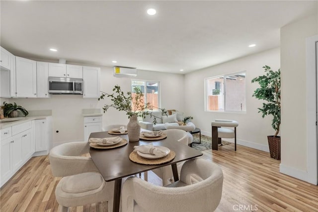 123 W 56th St, Los Angeles, CA 90037 - dining area with light wood-type flooring, recessed lighting, and a wall unit AC