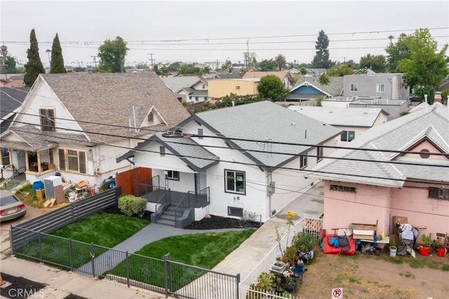 123 W 56th St, Los Angeles, CA 90037 - back of property featuring a fenced backyard, a residential view, and roof with shingles