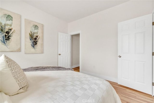 123 W 56th St, Los Angeles, CA 90037 - unfurnished bedroom featuring wood finished floors and baseboards