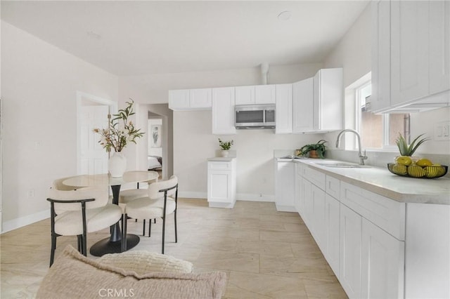 123 W 56th St, Los Angeles, CA 90037 - kitchen featuring stainless steel microwave, white cabinetry, and light countertops