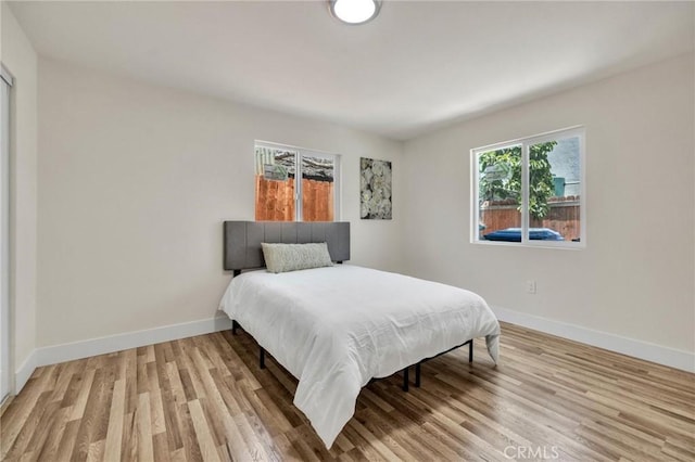 123 W 56th St, Los Angeles, CA 90037 - bedroom with light wood finished floors and baseboards