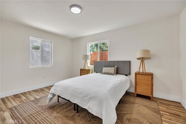 123 W 56th St, Los Angeles, CA 90037 - bedroom with baseboards and wood finished floors