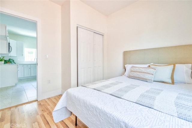 123 W 56th St, Los Angeles, CA 90037 - bedroom with light wood-type flooring and a closet