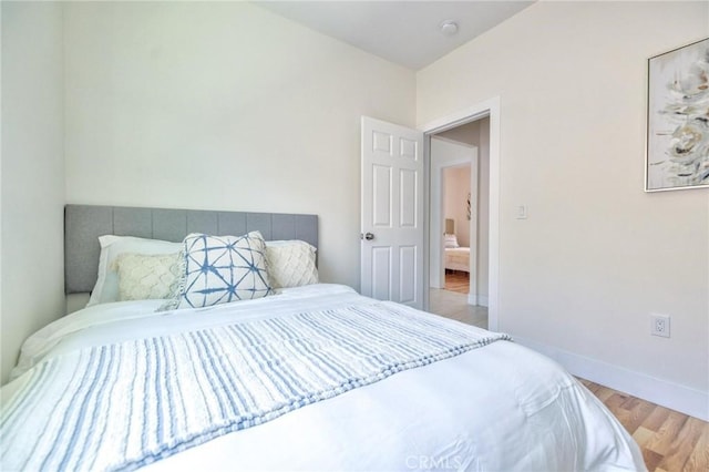 123 W 56th St, Los Angeles, CA 90037 - bedroom featuring wood finished floors and baseboards