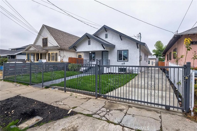 123 W 56th St, Los Angeles, CA 90037 - bungalow-style home with a fenced front yard, stucco siding, and a gate