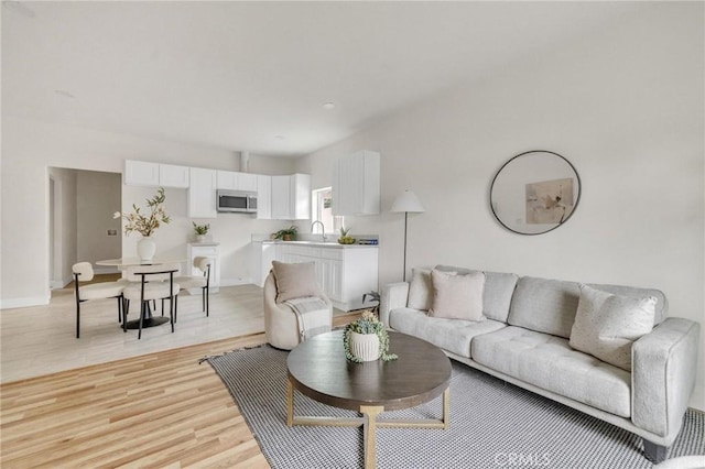 123 W 56th St, Los Angeles, CA 90037 - living area with light wood-style flooring and baseboards