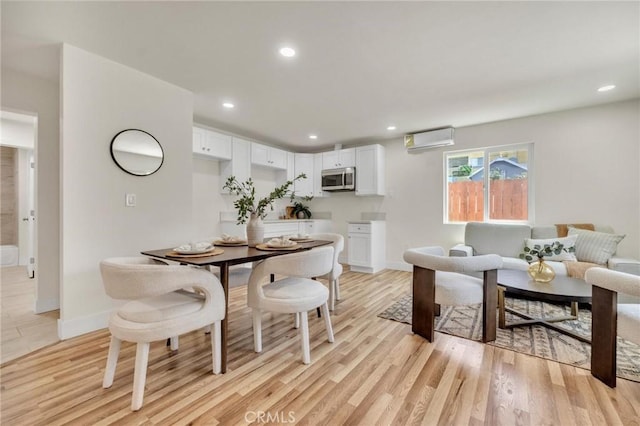 123 W 56th St, Los Angeles, CA 90037 - dining space with a wall mounted AC, light wood finished floors, and recessed lighting