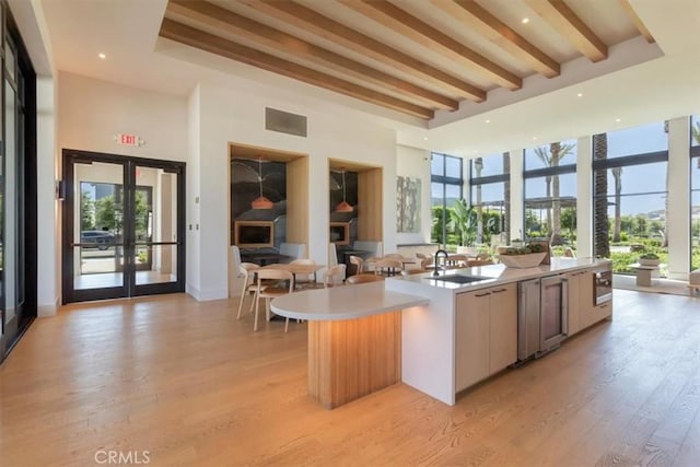 101 Mulberry Dr, Lake Forest, CA 92630 - kitchen with open floor plan, french doors, a high ceiling, light countertops, and light wood-style flooring