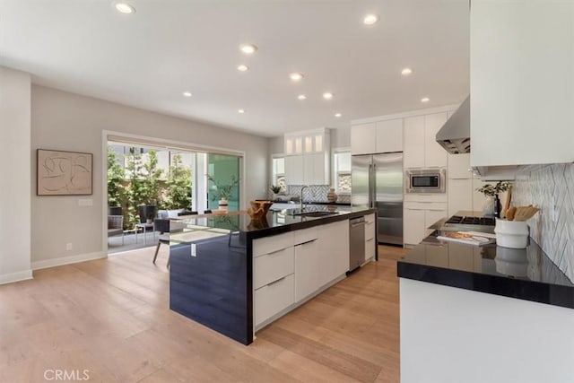 101 Mulberry Dr, Lake Forest, CA 92630 - kitchen with built in appliances, white cabinets, dark countertops, backsplash, and wall chimney exhaust hood