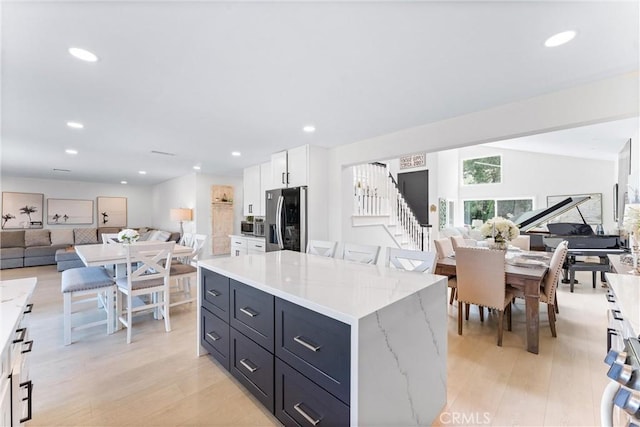 3208 Calle Grande, San Clemente, CA 92672 - kitchen featuring appliances with stainless steel finishes, open floor plan, light wood-style floors, white cabinets, and a kitchen island