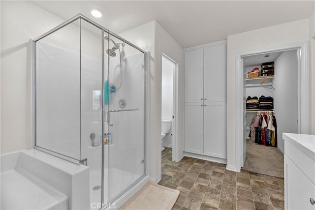 2694 Kings Canyon Dr, Jurupa Valley, CA 92509 - bathroom with a shower stall, a spacious closet, vanity, and stone finish floors