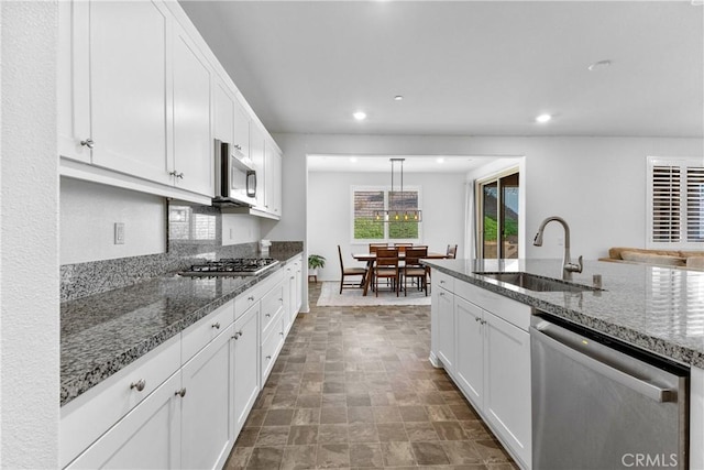 2694 Kings Canyon Dr, Jurupa Valley, CA 92509 - kitchen featuring stainless steel appliances, white cabinets, recessed lighting, dark stone counters, and stone finish flooring
