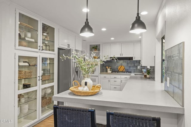 4071 Doane St, Ventura, CA 93003 - kitchen with stainless steel fridge with ice dispenser, white cabinets, backsplash, a peninsula, and glass insert cabinets