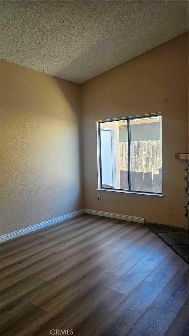 2031 Yucateca St, Perris, CA 92570 - unfurnished room featuring dark wood-type flooring, a textured ceiling, and a fireplace