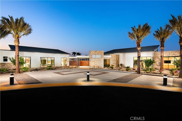 36342 Warren Dr, Palm Desert, CA 92211 - view of front of property featuring a standing seam roof, stucco siding, a metal roof, and stone siding
