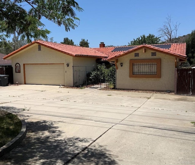 9168 Old Castle Rd, Valley Center, CA 92082 - mediterranean / spanish-style house featuring stucco siding, a tile roof, roof mounted solar panels, a chimney, and a garage