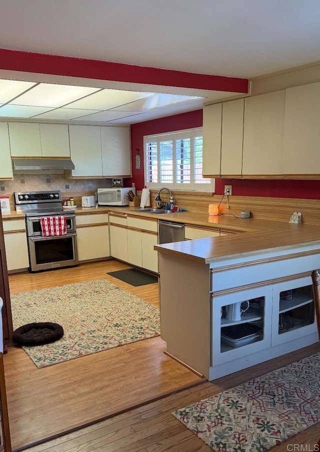 9168 Old Castle Rd, Valley Center, CA 92082 - kitchen with stainless steel appliances, under cabinet range hood, light wood-style floors, light countertops, and a peninsula