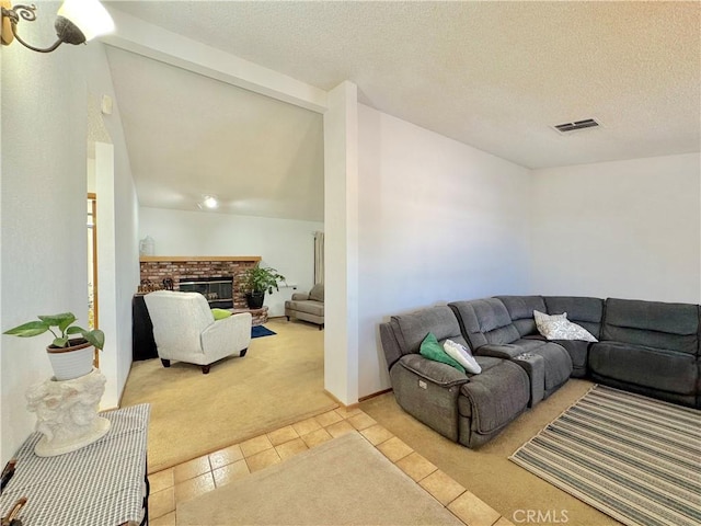 6774 Galleta Ave Unit 29, Palms, CA 92277 - living room with light colored carpet, light tile patterned floors, a brick fireplace, and a textured ceiling