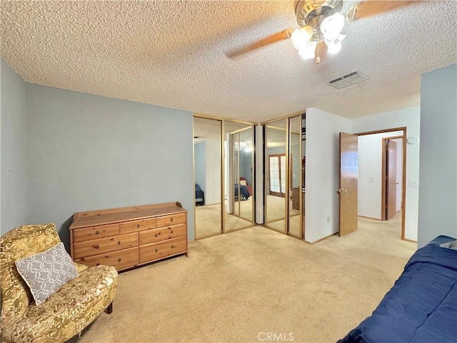 6774 Galleta Ave Unit 29, Palms, CA 92277 - carpeted bedroom with two closets, a ceiling fan, and a textured ceiling