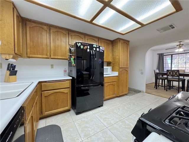 6774 Galleta Ave Unit 29, Palms, CA 92277 - kitchen with black appliances, arched walkways, brown cabinetry, light countertops, and a ceiling fan