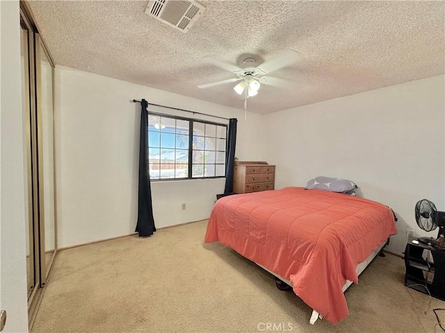 6774 Galleta Ave Unit 29, Palms, CA 92277 - bedroom with light colored carpet, a textured ceiling, and a ceiling fan