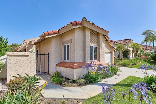 932 Alyssum Rd, Carlsbad, CA 92011 - view of front facade featuring a garage, stucco siding, a tile roof, a gate, and driveway