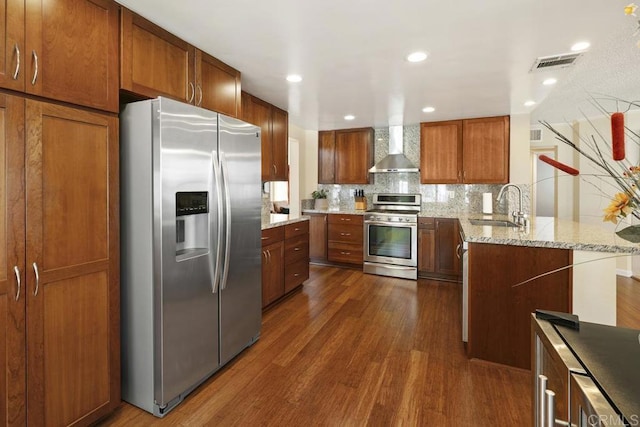 647 Boysenberry Way, Oceanside, CA 92057 - kitchen with appliances with stainless steel finishes, a peninsula, dark wood-type flooring, tasteful backsplash, and brown cabinets