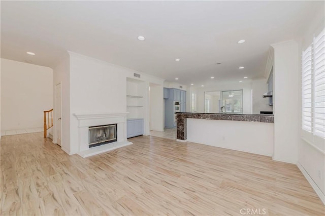 2768 Somerset Pl, Rowland Heights, CA 91748 - unfurnished living room featuring light wood-type flooring, recessed lighting, built in features, and a glass covered fireplace