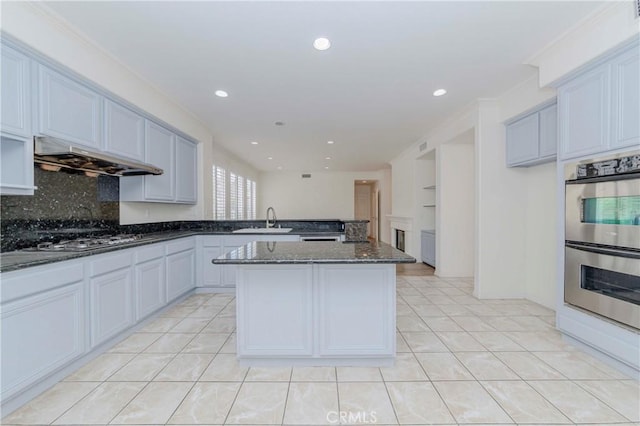 2768 Somerset Pl, Rowland Heights, CA 91748 - kitchen with stainless steel appliances, dark stone counters, a peninsula, under cabinet range hood, and light tile patterned flooring