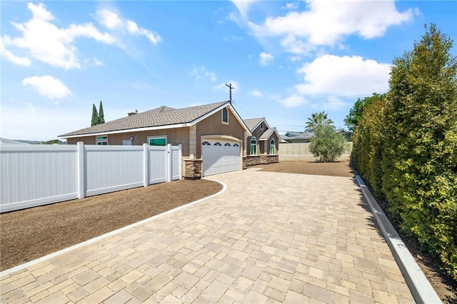 11128 Stamy Rd, Whittier, CA 90604 - view of front of home featuring an attached garage, decorative driveway, stucco siding, and stone siding
