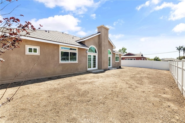 11128 Stamy Rd, Whittier, CA 90604 - back of property featuring stucco siding, a fenced backyard, and a chimney